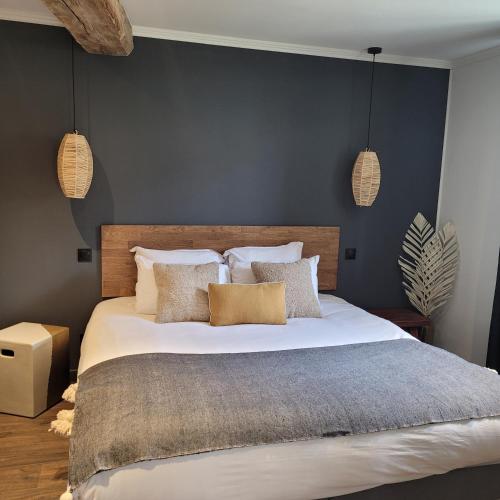 een slaapkamer met een groot wit bed met kussens bij Hôtel Rive Sud in Chinon