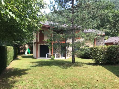 a house with a tree in the yard at Les Granges de Leo in Aston