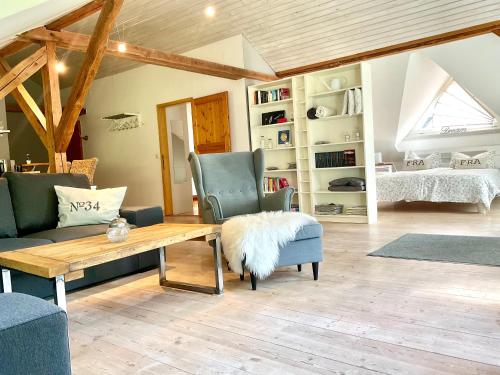 un soggiorno con un divano, un tavolo e delle sedie di Galerie Ferienwohnung a Handewitt