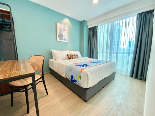 een slaapkamer met een bed en een tafel en stoelen bij Chill Suites Kuala Lumpur in Kuala Lumpur
