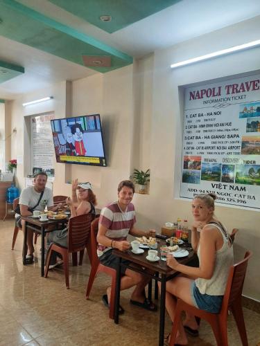 a group of people sitting at tables in a restaurant at Napoli Hostel Cat Ba in Cat Ba