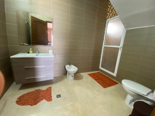 ein Badezimmer mit einem Waschbecken, einem WC und einem Spiegel in der Unterkunft La perla 