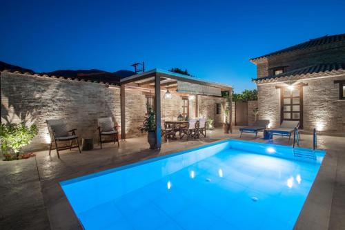 a swimming pool in a yard with a stone building at Villa Frontale - Restored Villa with Pool Perfect for 4 Nestled Next to a Traditional Olive Mill and Local Farms Offering Authentic Hospitality and Organic Delights By Villa Mana Gers in Kallithea