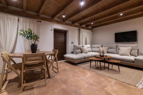 a living room with a couch and a table at Villa Frontale - Restored Villa with Pool Perfect for 4 Nestled Next to a Traditional Olive Mill and Local Farms Offering Authentic Hospitality and Organic Delights By Villa Mana Gers in Kallithea