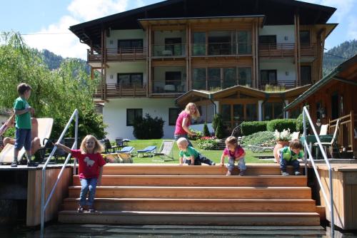 a group of children playing on stairs in front of a house at Carinthia in Weissensee