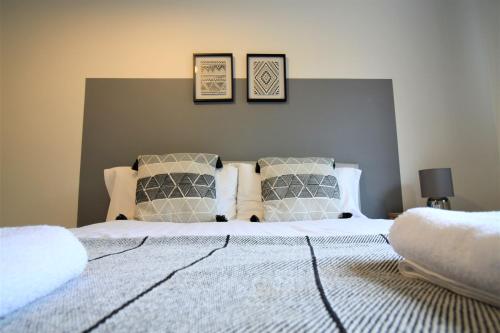 ein Schlafzimmer mit einem Bett mit zwei Bildern an der Wand in der Unterkunft Hamilton House -3 bed Close to Town, Drive Parking, 2 toilets in Newcastle upon Tyne