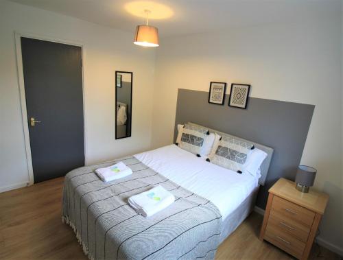 ein Schlafzimmer mit einem Bett mit zwei Handtüchern darauf in der Unterkunft Hamilton House -3 bed Close to Town, Drive Parking, 2 toilets in Newcastle upon Tyne