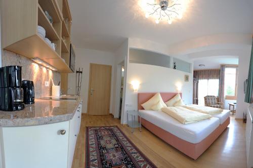 a kitchen and a living room with a bed in a room at Carinthia in Weissensee