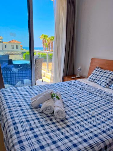 1 dormitorio con 1 cama azul y blanca y toallas en 3 Bedroom Coral Bay Beach Seaview Villa I Private Pool en Peyia