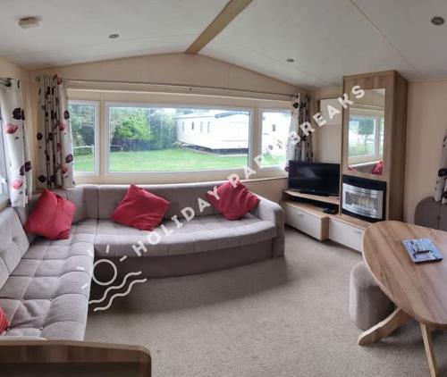 a living room with a couch and a table at Homely 2 bed @ Seal Bay Resort in Selsey