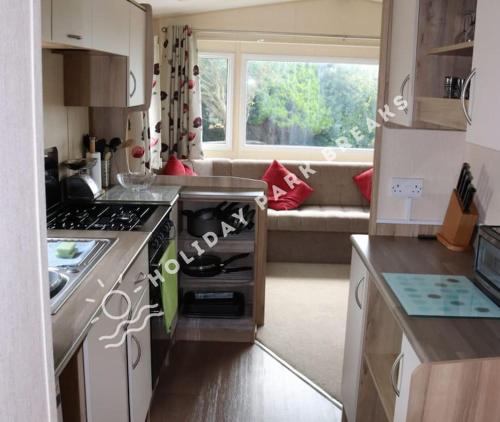 a small kitchen with a couch in a living room at Homely 2 bed @ Seal Bay Resort in Selsey
