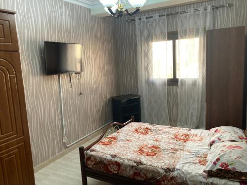 um quarto com uma cama e uma televisão na parede em Location appartement Oran Akid lotfi em Orã