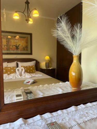 a bedroom with a bed with a vase on a table at Olive de Villa in Áyios Dhimítrios