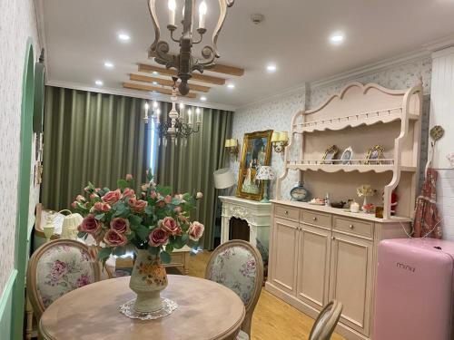 a kitchen with a table with a vase of flowers on it at Princess Vinhomes Smart City Apartment in Hanoi