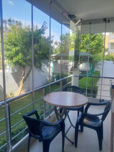 a table and two chairs on a balcony with a window at Konyaaltı Denize Yakın Kiralık Daire in Antalya