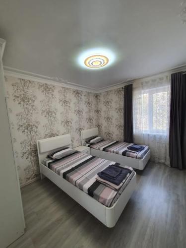 two beds sitting in a room with at Амид 3 in Khujand