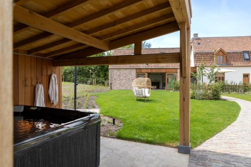 a pavilion with a koi pond in a yard at 't Hooiland in Lo-Reninge