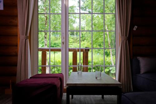a room with a table in front of a large window at The LODGE ABASHIRI in Abashiri