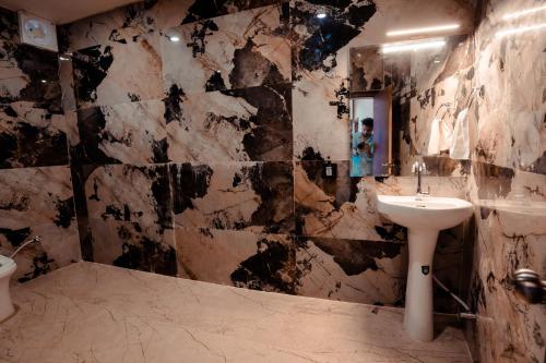La salle de bains est pourvue d'un lavabo et d'un miroir. dans l'établissement HOTEL JSR GANGA, à Varanasi