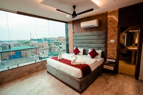 a bedroom with a large bed and a large window at HOTEL JSR GANGA in Varanasi