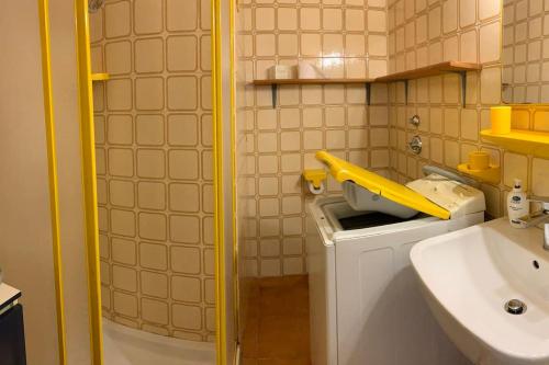 un piccolo bagno con lavandino e palo giallo di Appartamento Linus a Luino