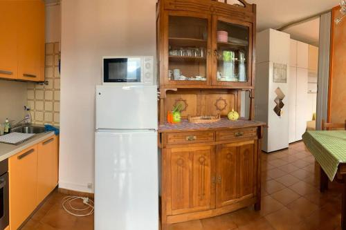 una cucina con frigorifero bianco e armadietti in legno di Appartamento Linus a Luino