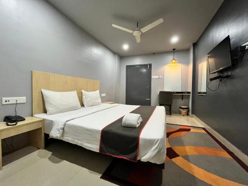 um quarto com uma cama grande e uma televisão em RJB Grand em Guwahati