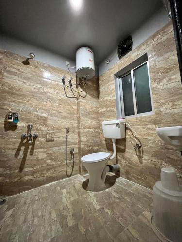 a bathroom with a toilet and a shower and a sink at RJB Grand in Guwahati