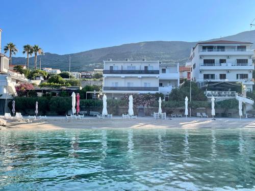 a beach with chairs and umbrellas in front of a building at J&D luxury apartment in Podstrana
