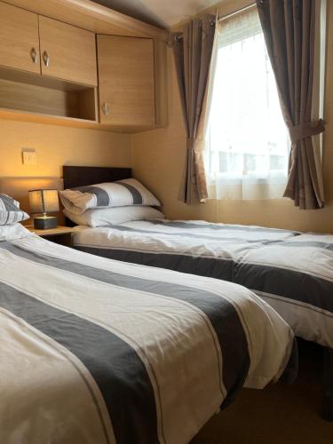 a hotel room with two beds and a window at Countryside 3-bedroom Static Caravan in Llanerchymedd