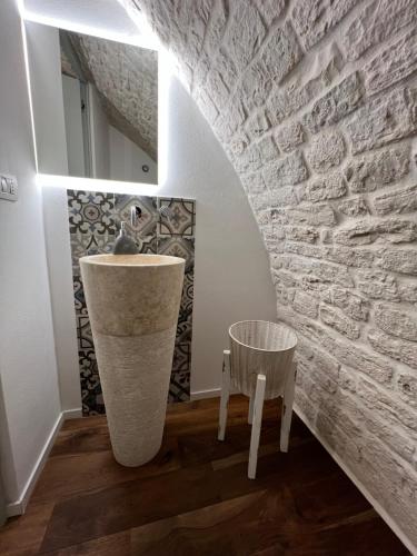 a bathroom with a stone wall and a sink at Dimora Pozzo Epifani in Noci