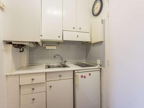 une cuisine avec des armoires blanches, un évier et un réfrigérateur dans l'établissement Studio central à Hendaye avec parking, proche commerces et plage - FR-1-2-434, à Hendaye