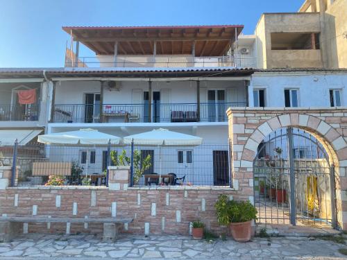 a building with a patio with tables and umbrellas at AngelView Apartments in Himare