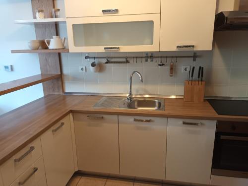 a kitchen with white cabinets and a sink at City Nest Apartment in Kobarid