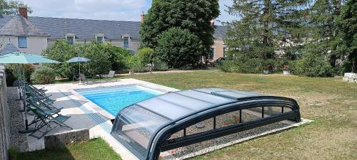 een zwembad in een tuin met een glazen brug bij La Varenne in Monthou-sur-Cher