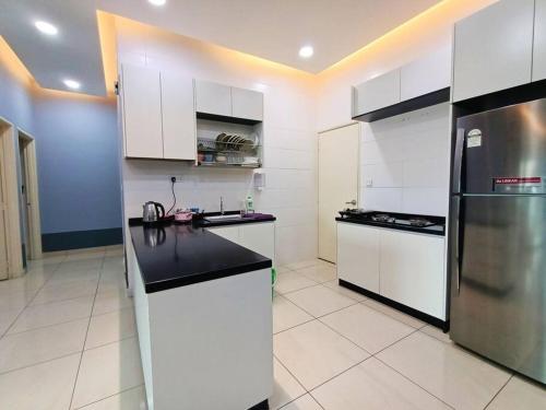 a kitchen with white cabinets and a stainless steel refrigerator at Johor Bahru Luxury Pinnacle Tower 3 Bed 2 Bath in Johor Bahru