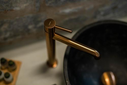 a brass sink faucet on top of a sink at Petra & Fos Boutique Hotel & Spa in Neon Oitilon