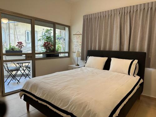 1 dormitorio con 1 cama grande y balcón en Roza Apartment, en Tel Aviv