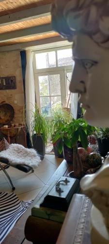 a mannequin sitting at a table in a room with plants at Campagne et Mer in Saint-André-de-Lidon