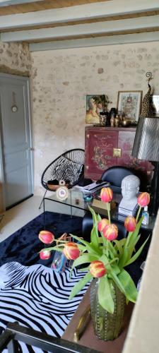 a room with a bed and a table with flowers at Campagne et Mer in Saint-André-de-Lidon