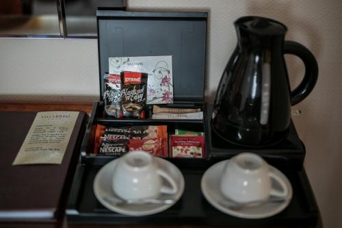 a table with two white bowls and a vase on it at Hotel Villa Breg in Vršac