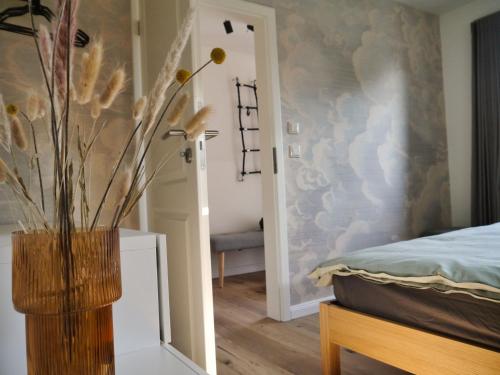 ein Schlafzimmer mit einer Vase mit Blumen darin in der Unterkunft Der Schuppen in Mildstedt