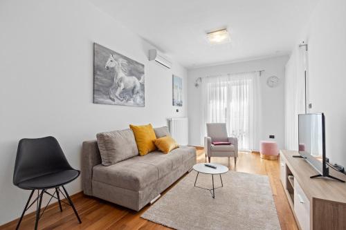a living room with a couch and a tv at Feniks Fažana apartman in Fažana