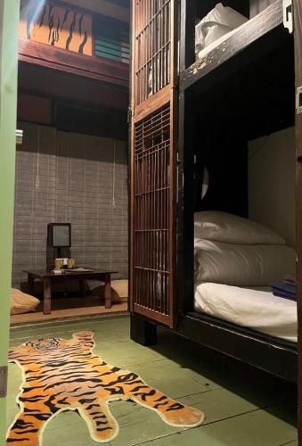 a room with a tiger rug on the floor next to a bunk bed at Villa Sacra in Kamakura
