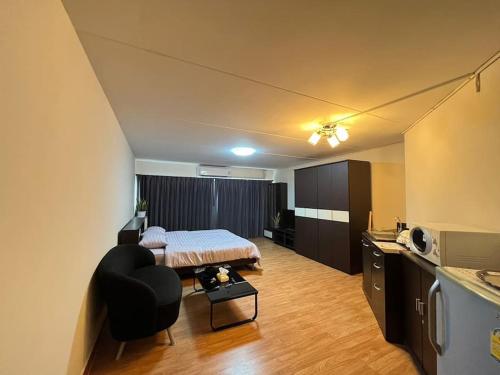 a bedroom with a bed and a chair in a room at T12 Popular Condo By : hunnity in Ban Bang Phang