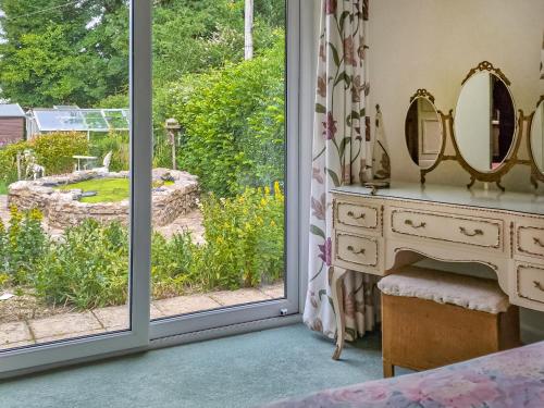 a bedroom with a window looking out at a garden at Woodstock in Chard