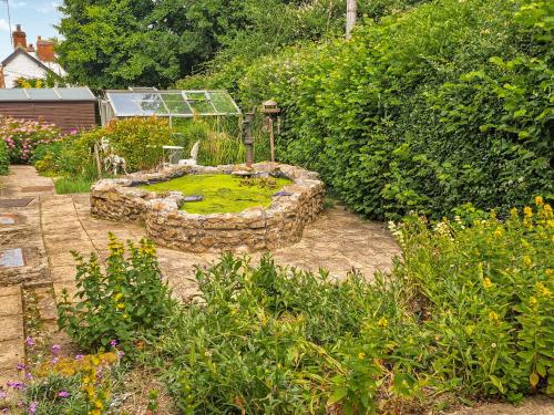 einen Garten mit einem Steinkreis in der Mitte in der Unterkunft Woodstock in Chard