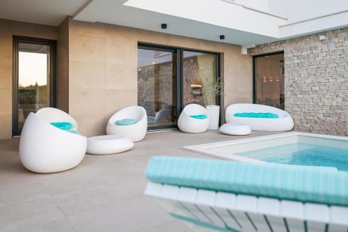patio con sedie bianche e piscina di Villa Fortunal a Murter