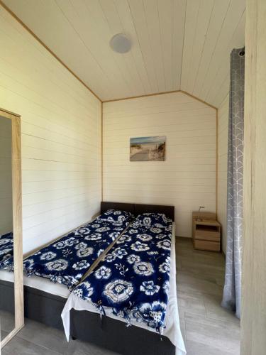 JezierzanyにあるBursztynowy Zakątekのベッドルーム1室(青と白の掛け布団付きのベッド1台付)