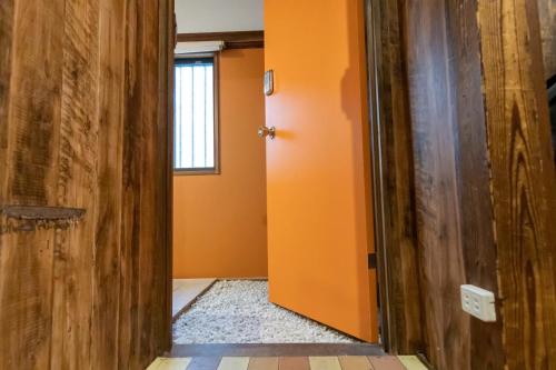 a hallway with an orange wall and a door at Villa Sacra in Kamakura